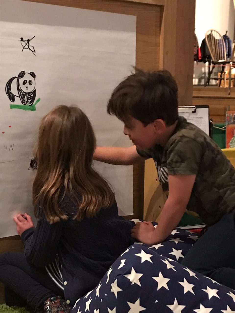 Children drawing pictures on  a board